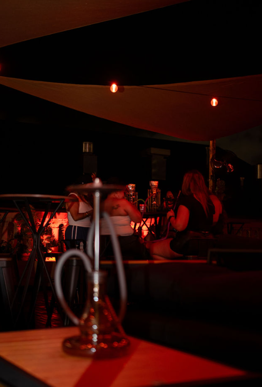 Hookah on a table with the lounge glowing behind