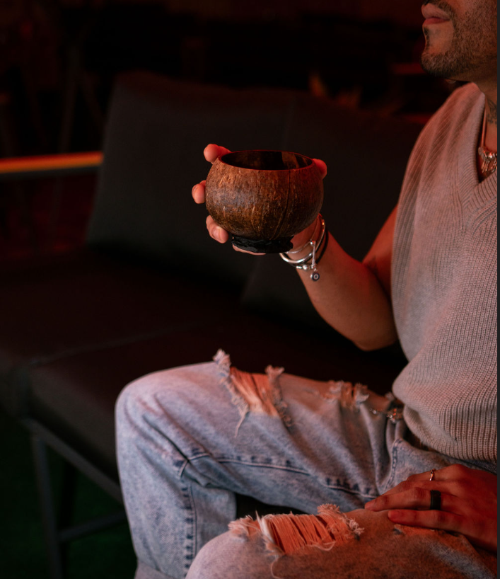 Guest holding a coconut cocktail on lounge seating